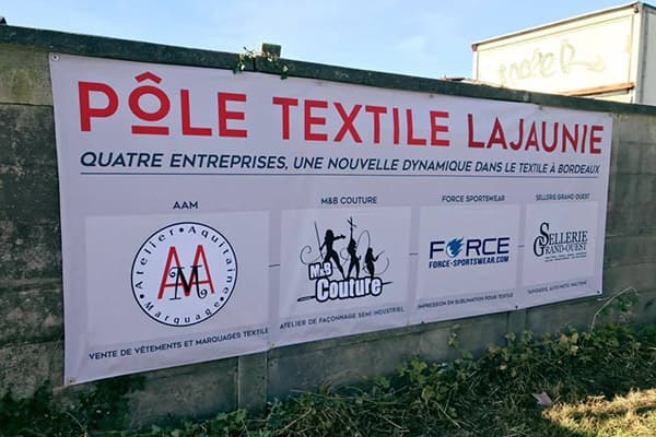 grijze banner 'pole textile' op betonnen muur