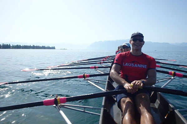 sport rowers on lake wearing red compression tops with lausanne writing