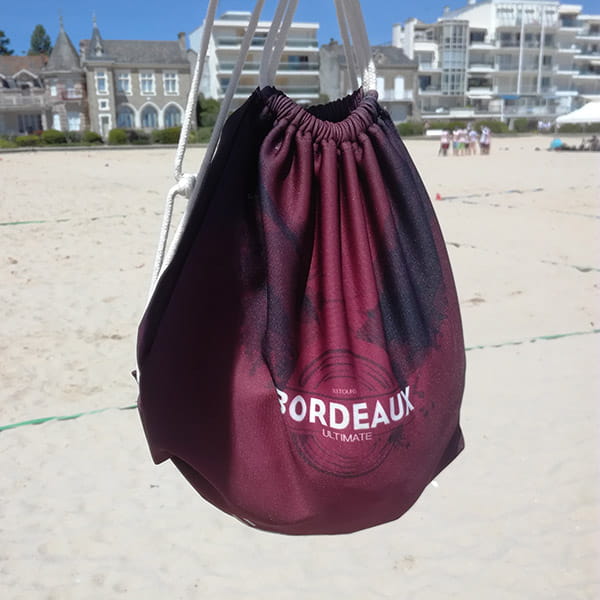 sac à cordon bordeaux suspendu à la plage