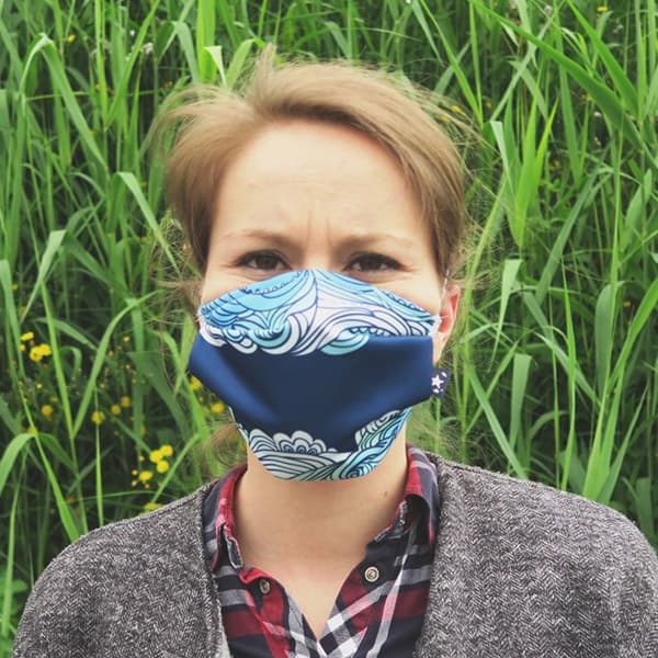 vrouw die een mondmasker met blauwe golven draagt
