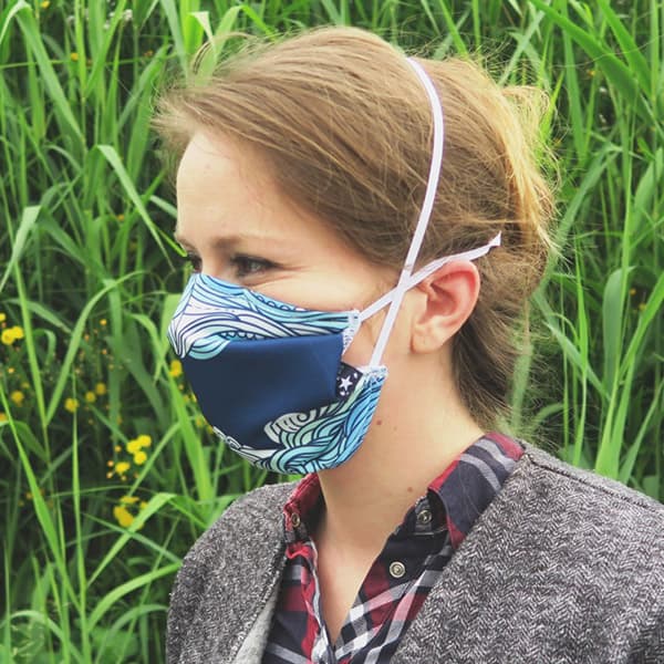 zijaanzicht van een vrouw die een mondmasker met blauwe golven draagt