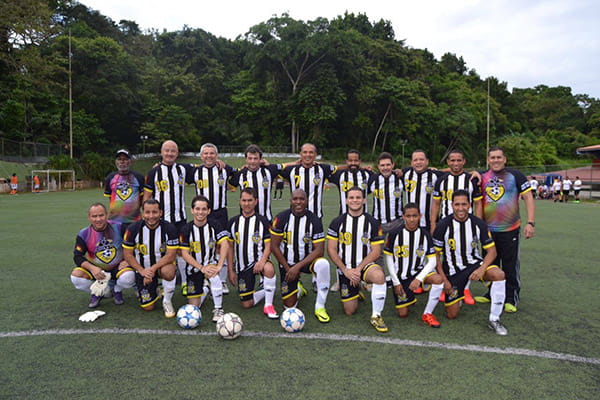 l'équipe de football loyola portant des maillots sublimés noirs et jaunes posant sur un terrain en herbe
