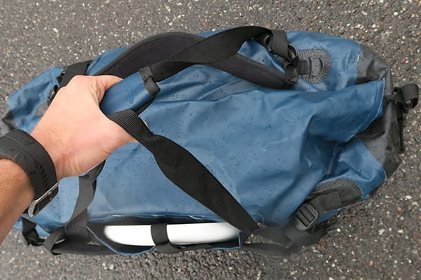 hand holding duffle bag by straps