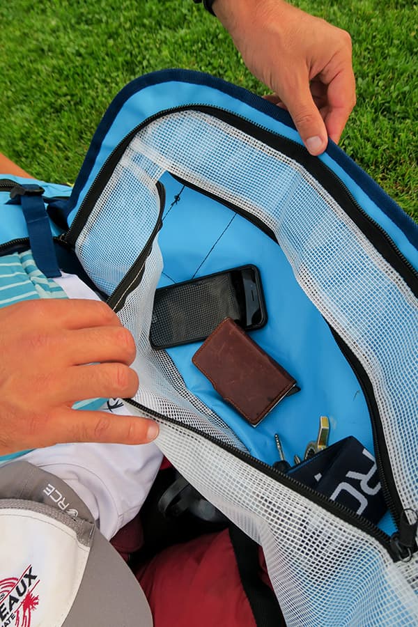 hands opening inner pocket on light blue waterproof bag