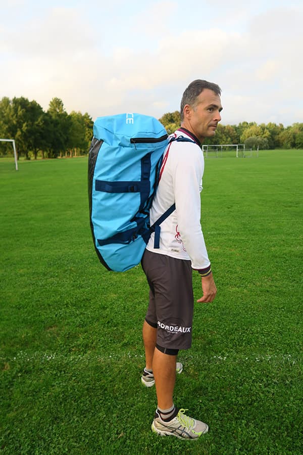 man wearing light blue waterproof bag on his back