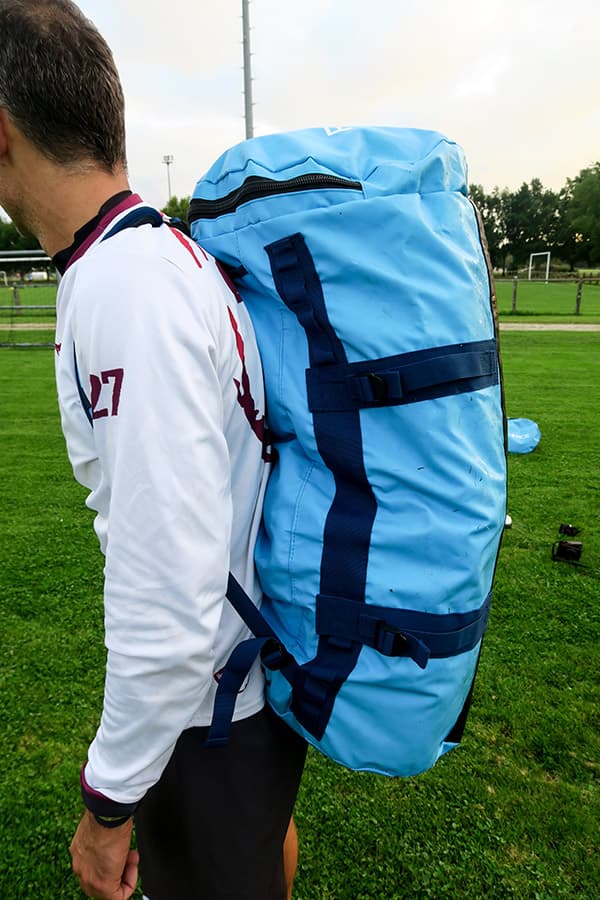 man wearing blue waterproof bag on his back