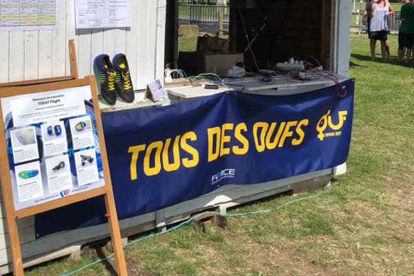 blue outside banner with tous des oufs yellow writing