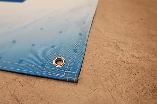 partial view of corner of blue banner with eyelet