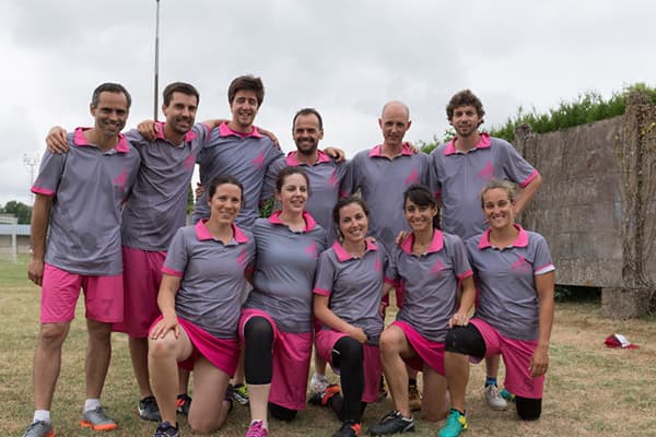 team of players posing in grey and pink polo shirts