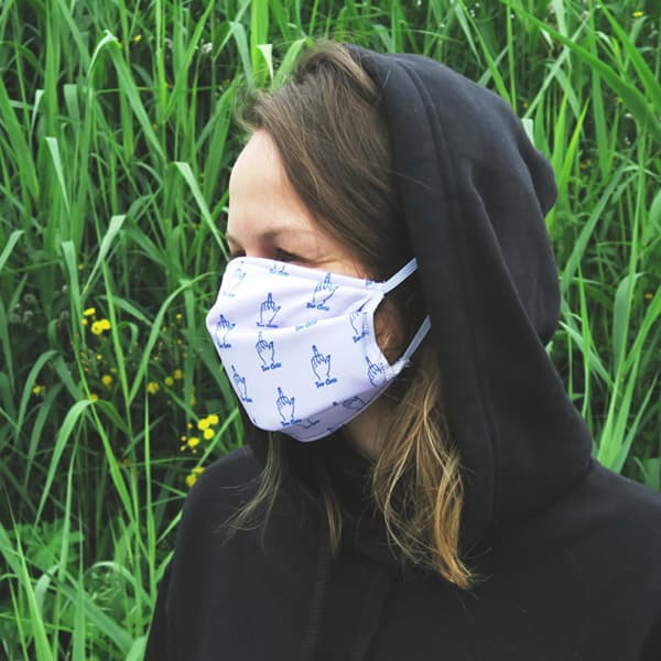 femme avec capuche noire portant un masque barrière blanc