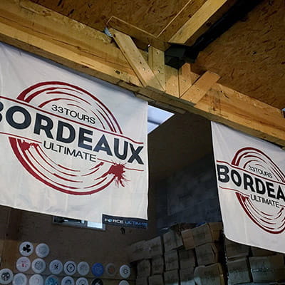 two white bordeaux flags hanging from wood ceiling