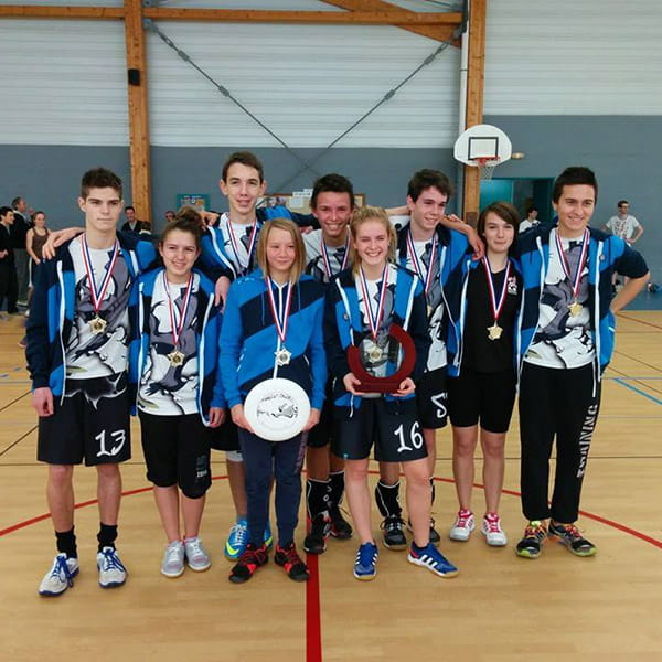 young ultimate team indoor posing with medal