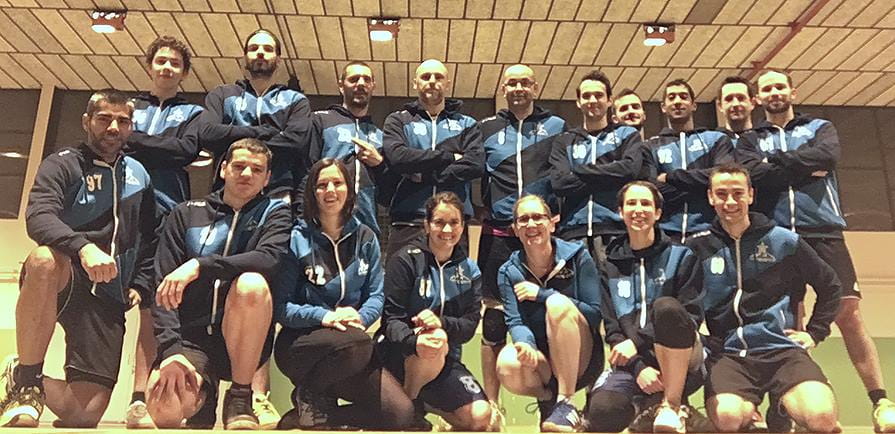 team indoor posing in stripped dark and light blue vest
