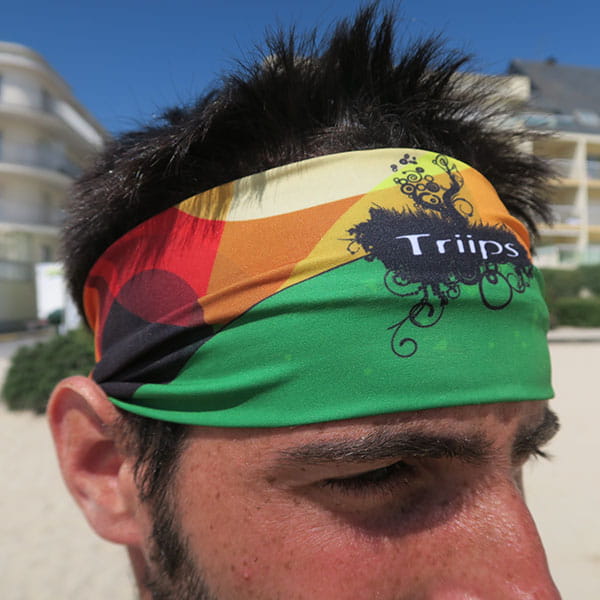 head of man wearing a green and orange headband at the beach