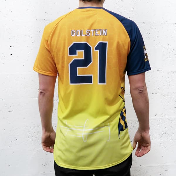 back of man wearing a yellow gradient and blue raglan sport jersey #21