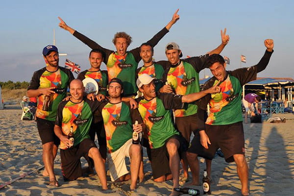happy sport team on sunset beach wearing colourful jerseys