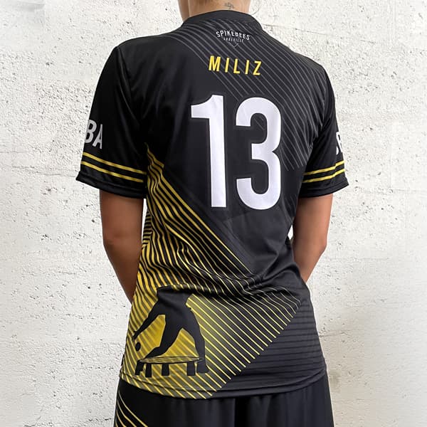 back of woman wearing a black and yellow sublimated jersey #13