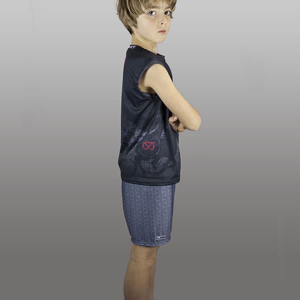 side view of kid wearing grey shorts and black singlet arms crossed