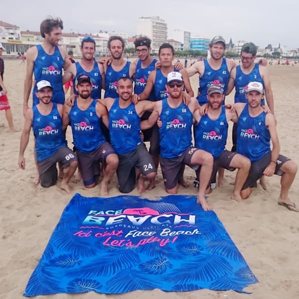 sport team posing in front of blue beach towel