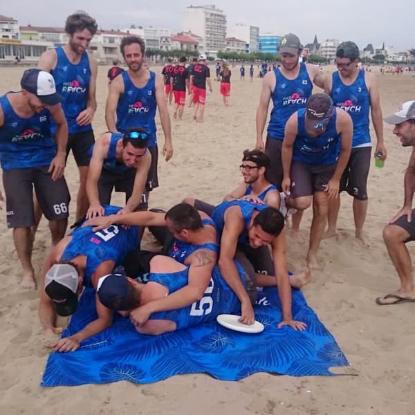 sport team falling on a blue beach towel