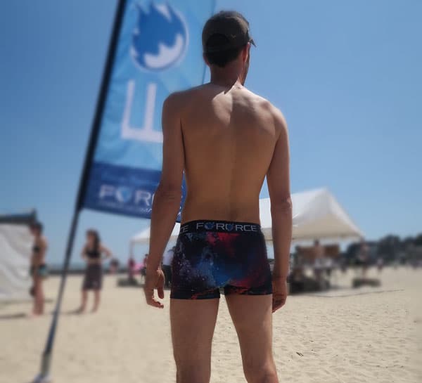 back of man body wearing blue sublimated underwear on beach